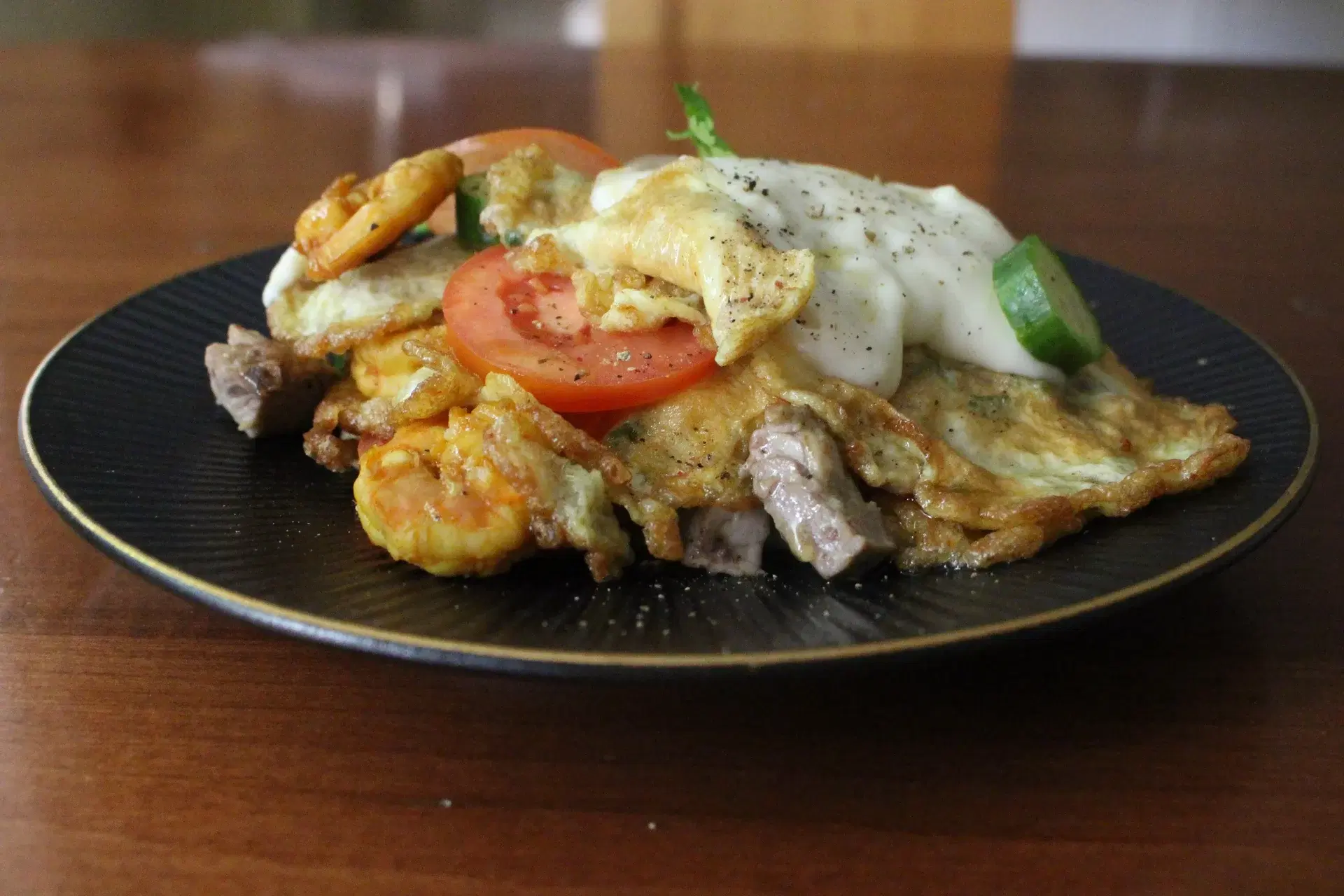 Parsi poro, layered with prawns, mutton, tomato and cucumber and béchamel sauce.