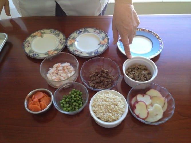 An assortment of ingredients in bowls, likely for preparing Beefy Pilaf for Dogs.