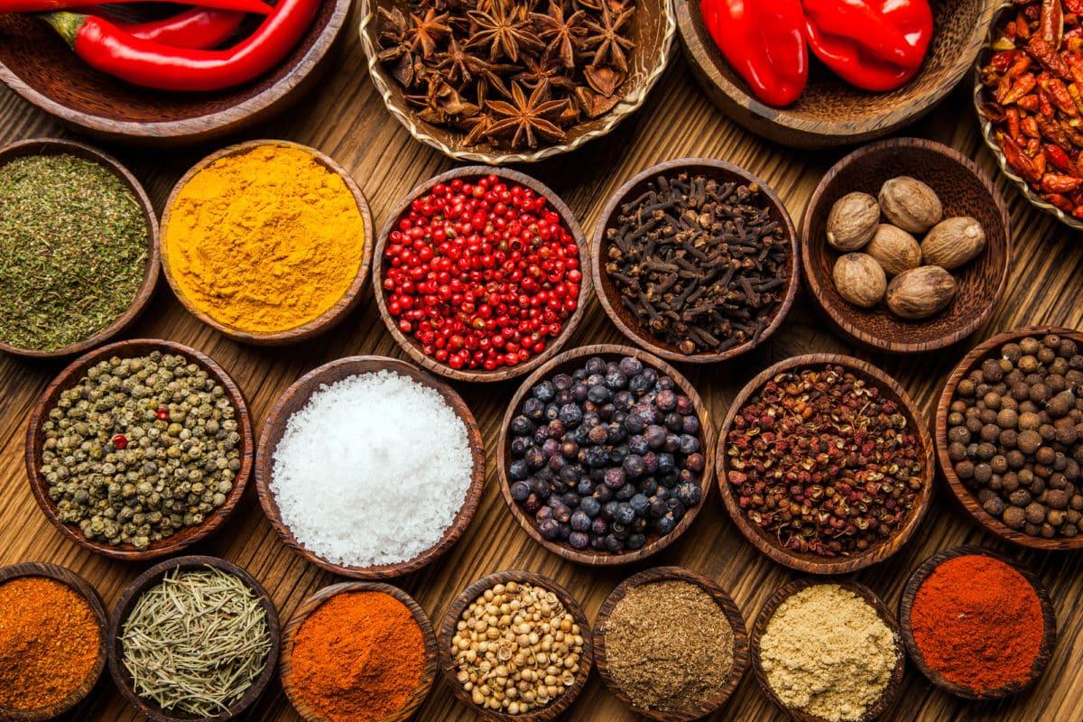 Array of vibrant Latin spices in wooden bowls.